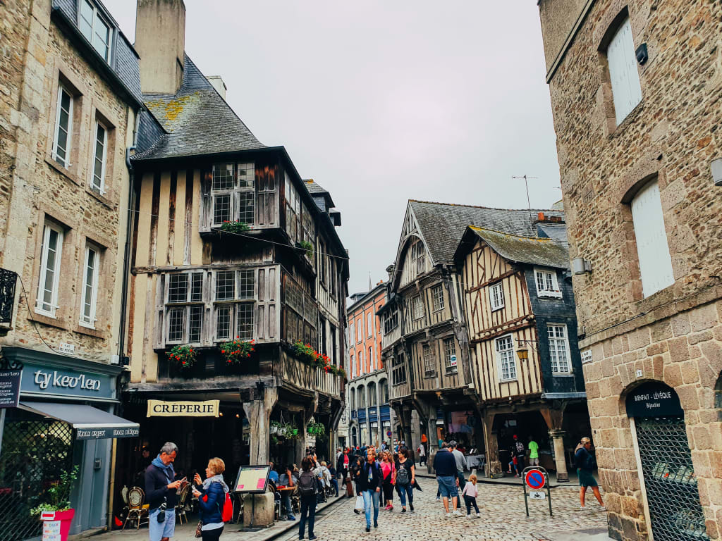 Strada acciottolata con case a graticcio nella città medievale di Dinan, Bretagna, Francia.
